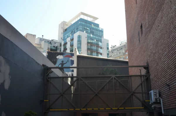 Modern buildings contrast with urban textures in Córdoba, Argentina, showcasing vibrant city life against a clear sky.