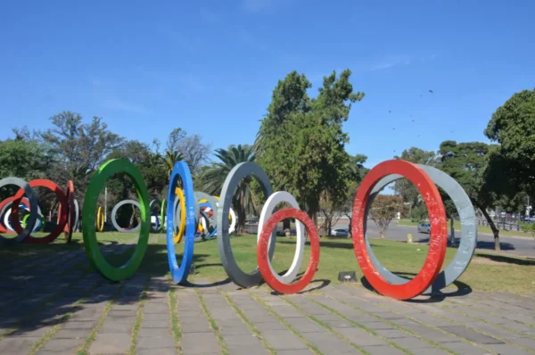 Colorful circular sculptures arranged in a park setting in Córdoba, Argentina, with clear blue skies and greenery in the background.