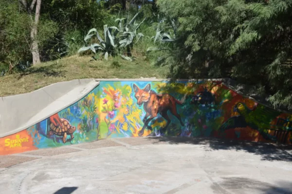 Vibrant graffiti mural featuring wildlife and tropical plants on a skate park wall in Córdoba, Argentina.