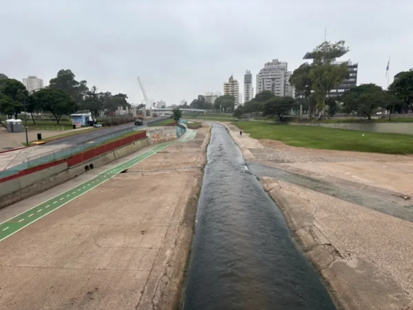 Flowing river surrounded by urban buildings and green spaces in Córdoba, Argentina, showcasing a blend of nature and city life.