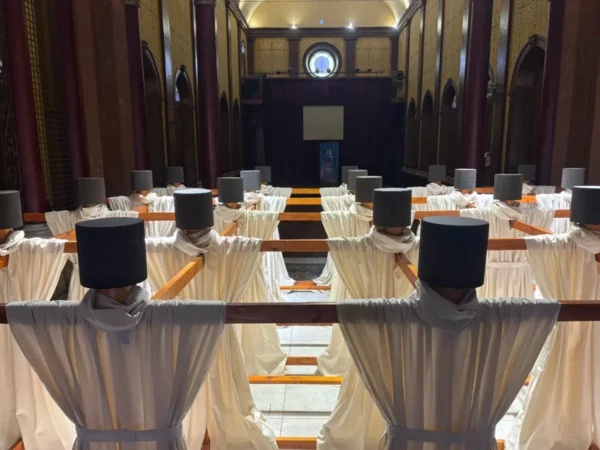White draped structures with dark hats lined up in rows inside a historic building in Córdoba, Argentina, creating a striking composition.