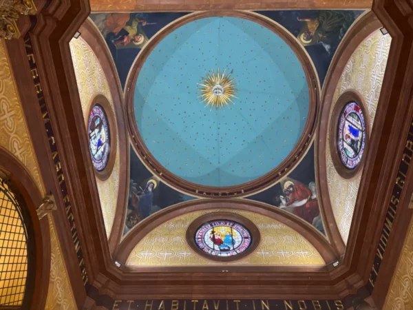 Vibrant decorative ceiling featuring a central sunburst and stained glass details in Córdoba, Argentina.