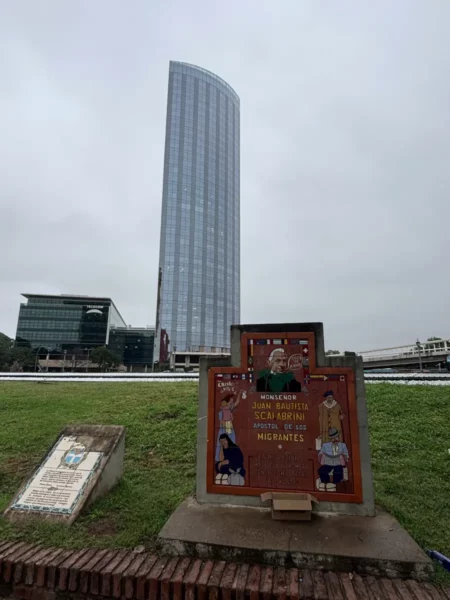 Colorful street art in front of a modern skyscraper in Córdoba, Argentina, showcases local culture against a cloudy sky.