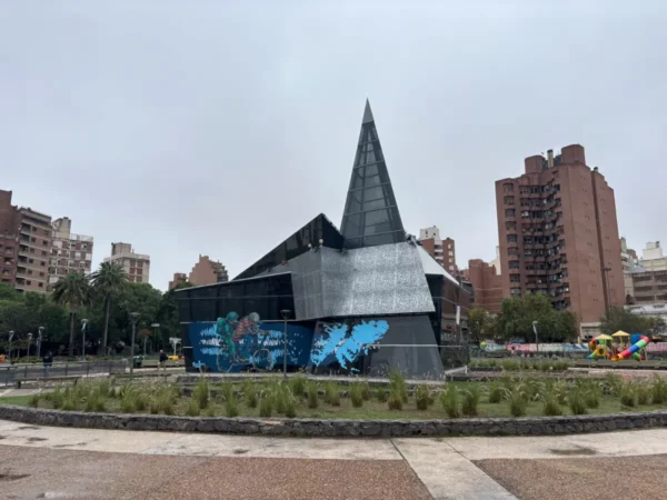 Architectural structure with a pointed roof and modern design, surrounded by greenery in Córdoba, Argentina.