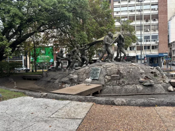 Bronze statue depicting historical figures on a rocky base, surrounded by greenery in Córdoba, Argentina.