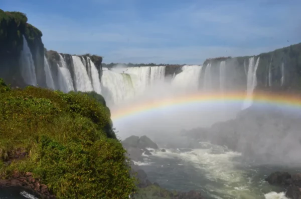 rainbow in front of iguazu falls seen from the brazilian side