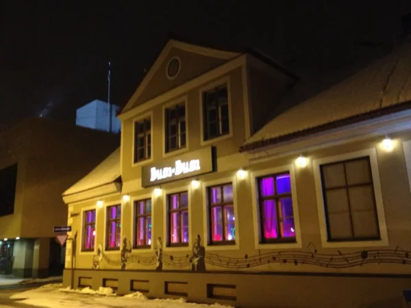 Colorful lights illuminate the Pärnu building, highlighting its charming architecture and musical decor on a winter night.