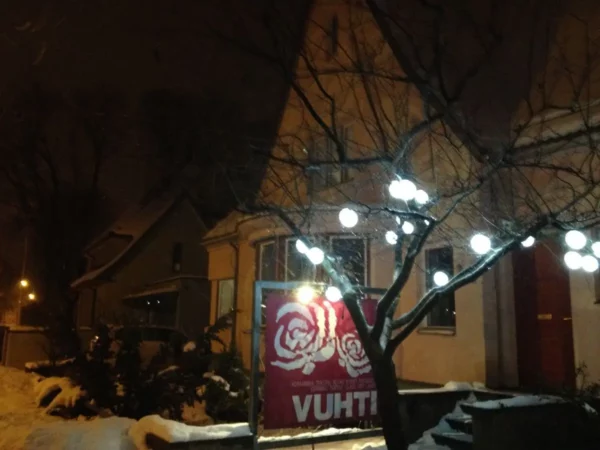 Warmly lit decorations on a snowy evening outside a building in Parnu, enhancing the cozy atmosphere of winter.