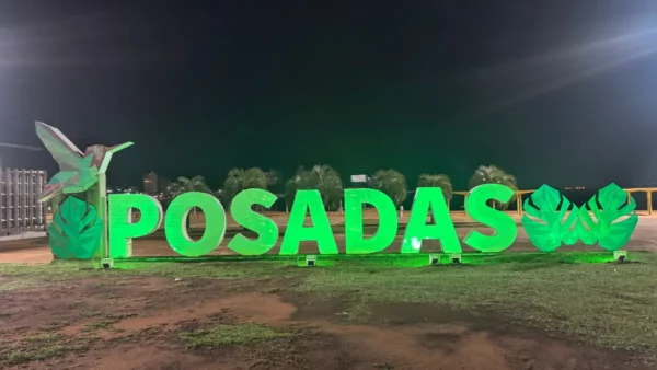 Lit name sign of posadas city, argentina adorned with a hummingbird