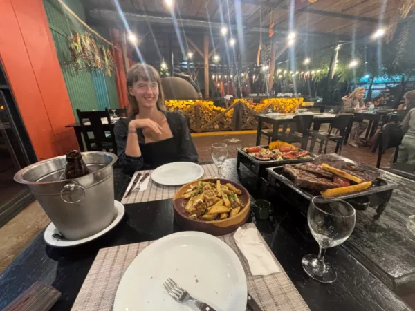 girl at table with served argentine parilla and cold beer in grill restaurant in puerto iguazu
