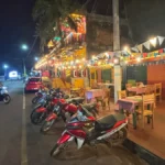 parked motorbikes in front of brightly lit restaurant in puerto iguazu, argentina
