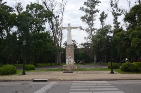 Christ the Redeemer statue stands tall amidst lush greenery in a park in Rosario, Santa Fe, Argentina, creating a serene atmosphere.