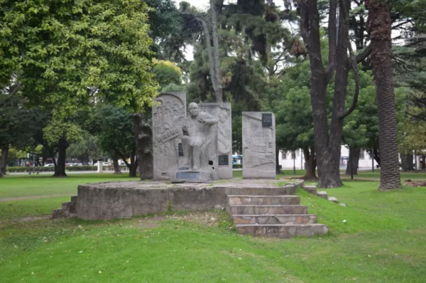Sculptural monument amid lush greenery in Rosario, Santa Fe, Argentina, featuring stone carvings and surrounding trees.