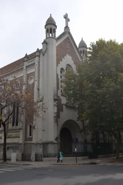 Historic architecture with ornate details and a cross, framed by trees in Rosario, Santa Fe, Argentina.