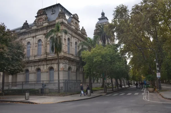 Historic architecture and lush trees line the streets of Rosario, Santa Fe, Argentina, with a hint of overcast sky in the background.