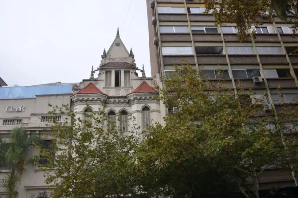 Historic architecture stands alongside modern buildings in Rosario, Santa Fe, Argentina, framed by lush greenery.