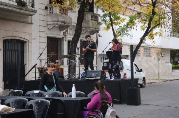 Live musicians perform on a stage in Rosario, Santa Fe, Argentina, with seated guests enjoying the outdoor atmosphere.