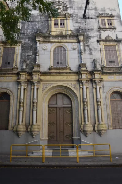 Historic building facade with intricate yellow detailing and wooden doors in Rosario, Santa Fe, Argentina.