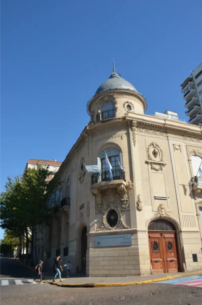 Elegant architecture with a dome and decorative details contrasts against a clear blue sky in Rosario, Santa Fe, Argentina.
