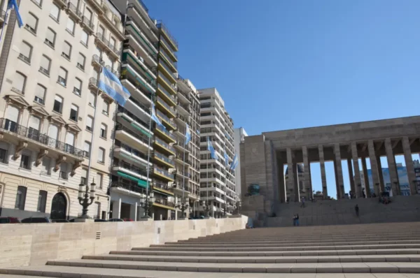 Rosario's modern architecture contrasts with historic columns under a clear blue sky in Santa Fe, Argentina.