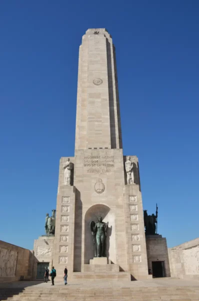 Monumental tower showcasing intricate sculptures and clear blue skies, located in Rosario, Santa Fe, Argentina.