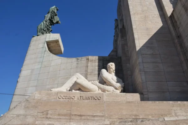 Oceano Atlantico statue elegantly reclines in Rosario, Santa Fe, Argentina, showcasing detailed stonework against a clear blue sky.
