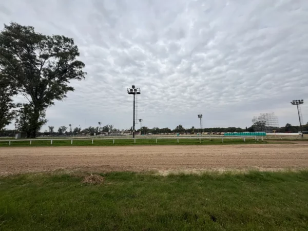 Horse racing track with cloudy skies and green grass in Rosario, Santa Fe, Argentina, set against an expansive horizon.
