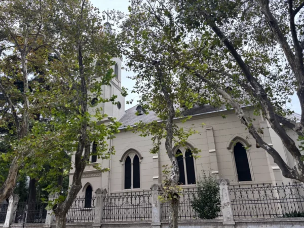 Historic building with Gothic-style architecture, framed by lush trees in Rosario, Santa Fe, Argentina.