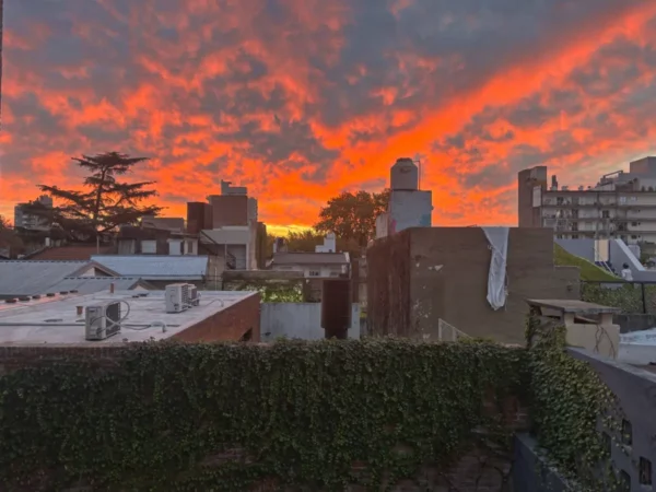 Vibrant sunset colors illuminate the skyline over rooftops in Rosario, Santa Fe, Argentina, creating a stunning evening view.