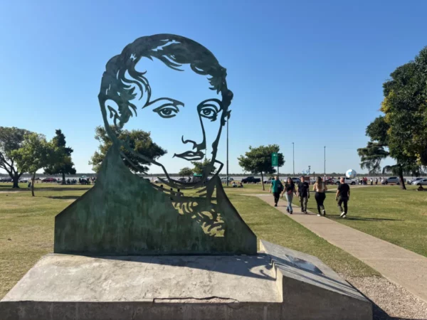 Statue of a prominent figure in a park setting, with green grass and blue skies in Rosario, Santa Fe, Argentina.