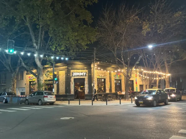 Vibrant night scene at Jimmy's in Rosario, Santa Fe, Argentina, with illuminated trees and bustling street activity.