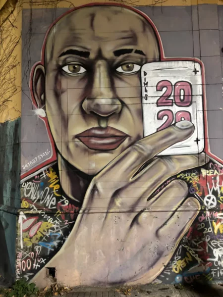 Murals showcasing vibrant street art with a large portrait of a man holding a calendar, located in Rosario, Santa Fe, Argentina.