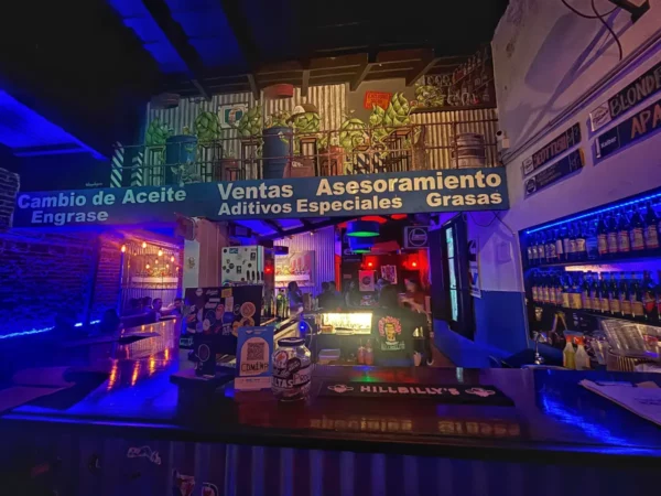 Vibrant interior of a bar in Rosario, Santa Fe, Argentina, featuring colorful lighting and a lively atmosphere with a well-stocked counter.