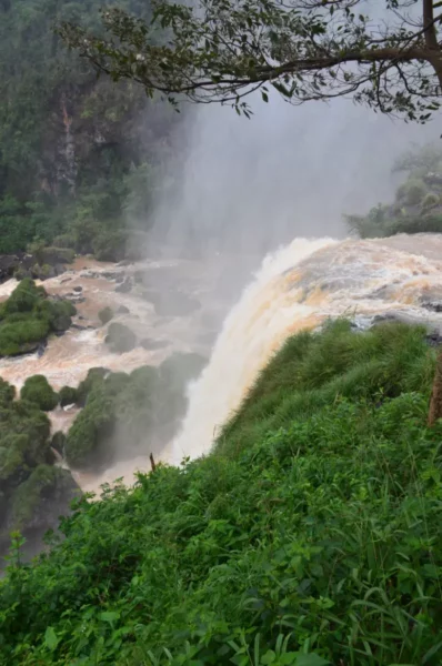 Majestic saltos del Monday Falls cascading over rocky cliffs, surrounded by lush greenery in Paraguay.