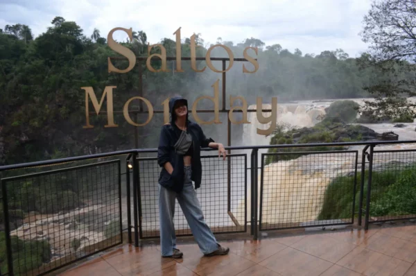 girl traveler posing in front of signs at monday falls in paraguay