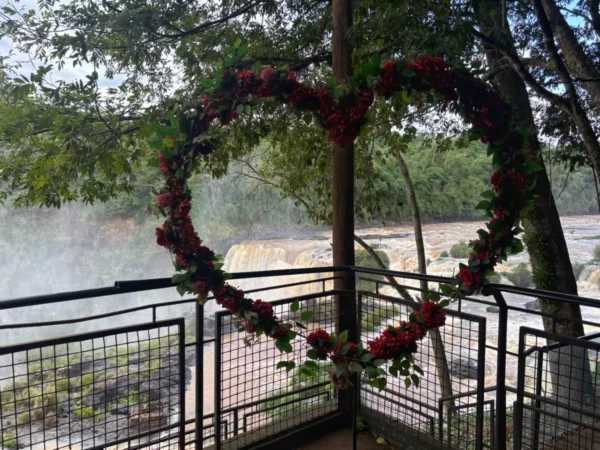 Heart-shaped floral frame overlooks the stunning Salto del Monday Falls, surrounded by lush greenery in Paraguay.