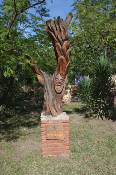 Wood sculpture of laughing face in san marcos sierras, cordoba