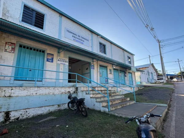 Historic building with blue accents and stairs, situated in Villarica, Paraguay, showcasing local architecture and surroundings.