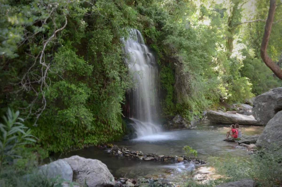 two women Sitting below platanistos waterfall in south evia