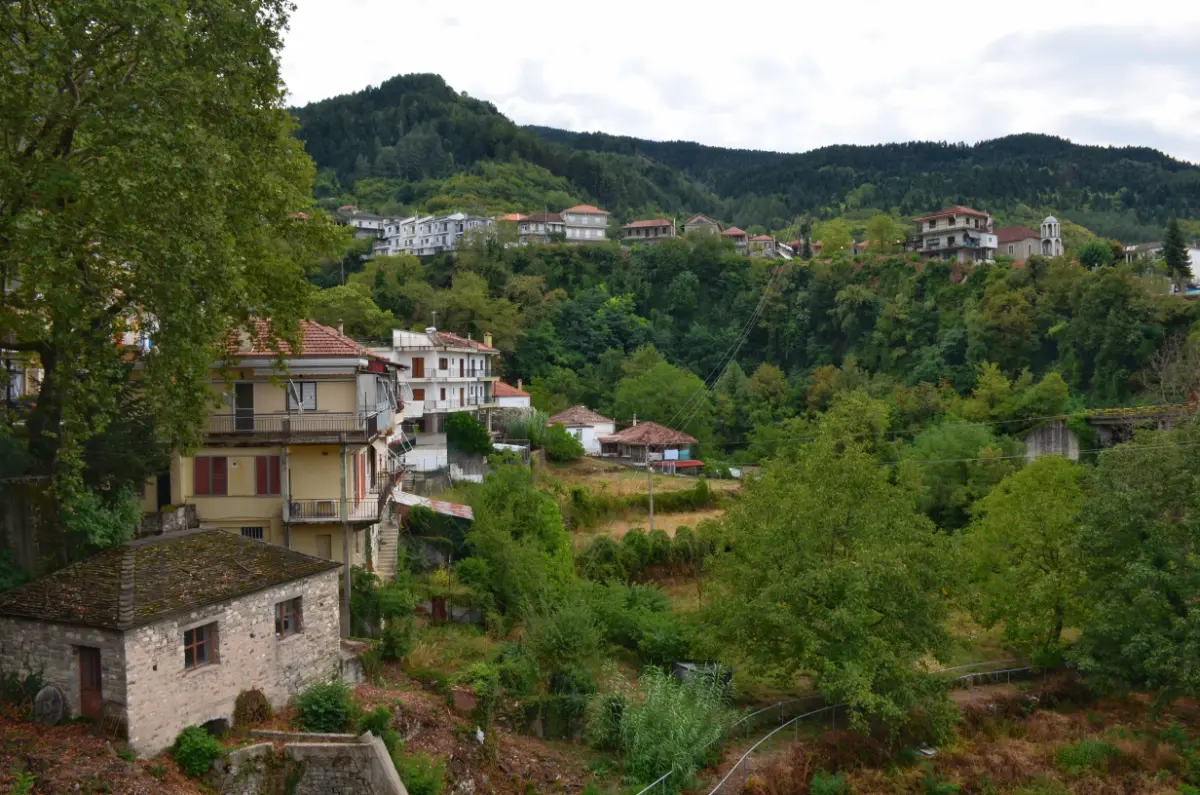 Agnanta village in Tzoumerka — stone houses scattered across green hills and forested slopes.