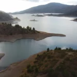 Aoos Springs Lake near Metsovo, panoramic view of the alpine reservoir with forested hills and small islets in Epirus, Greece