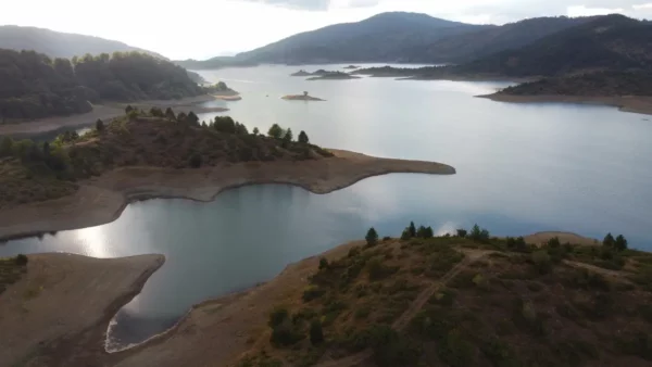 Aoos Springs Lake near Metsovo, panoramic view of the alpine reservoir with forested hills and small islets in Epirus, Greece