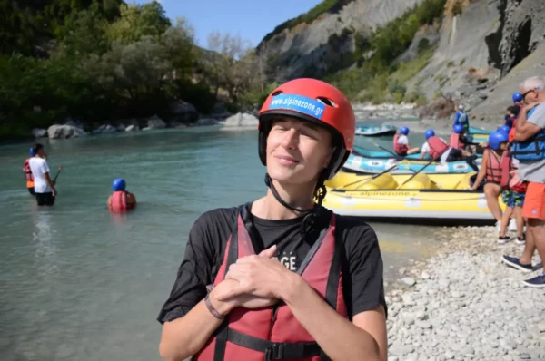 Rafting enthusiasts prepare on the banks of the Arachthos River, surrounded by lush greenery and rocky cliffs in Ioannina, Greece.