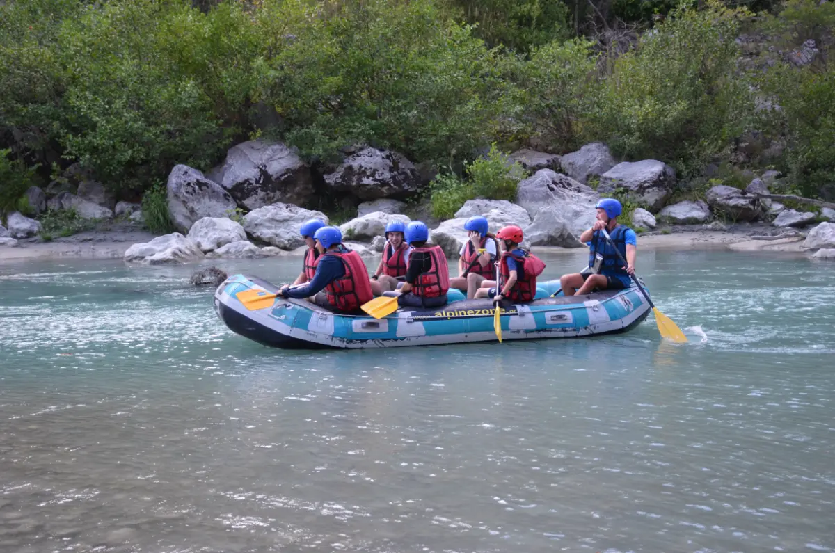 Raft with a small group floating calmly along the Arachtos River in Tzoumerka, surrounded by rocks and greenery