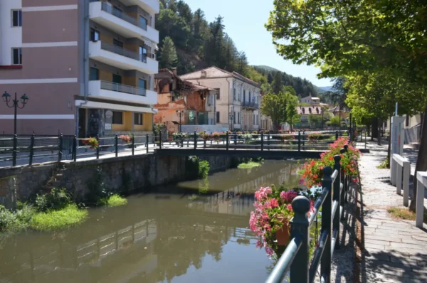 Charming streets lined with colorful flowers and a tranquil river in Florina, Greece, showcasing its picturesque scenery.