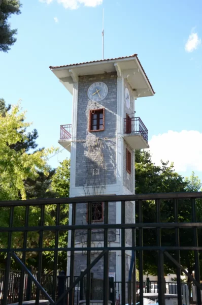 Florina features a historic clock tower surrounded by lush greenery, showcasing a blend of natural and architectural beauty.