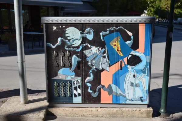 Colorful street mural with abstract designs and local motifs, showcasing vibrant art in the city of Florina, Greece.