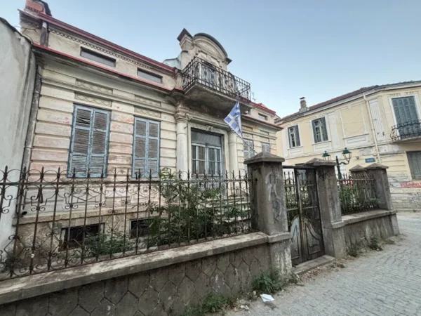 Historic architecture with ornate details and a decorative iron fence in Florina, Greece, showcasing local charm and character.
