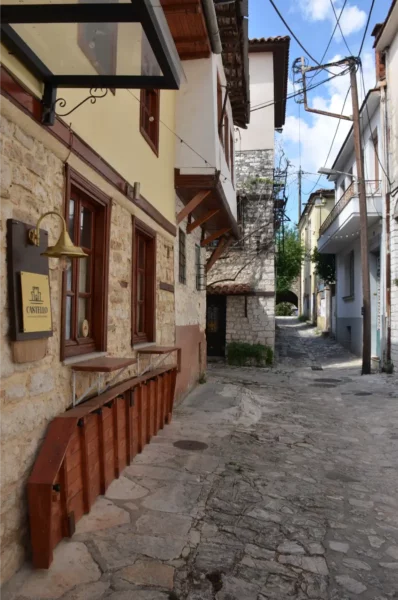 Charming cobblestone street with traditional stone buildings and rustic balconies in Ioannina, Greece.