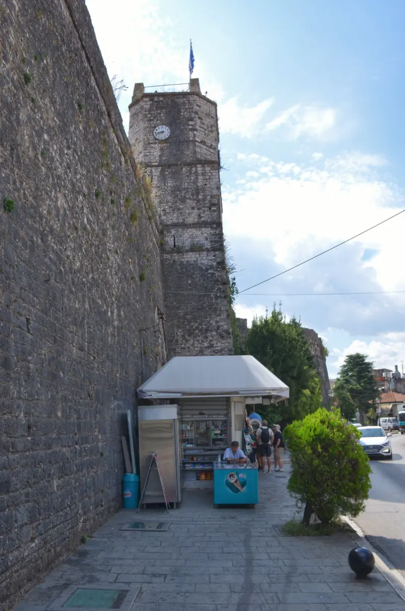 clocktower by the main entrance of Ioannina Castle, with the stone walls and a small street kiosk in the foreground, Ioannina, Greece
